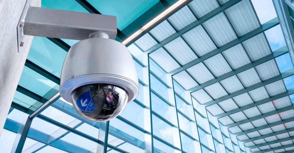 Security, CCTV camera for office building at night in London.